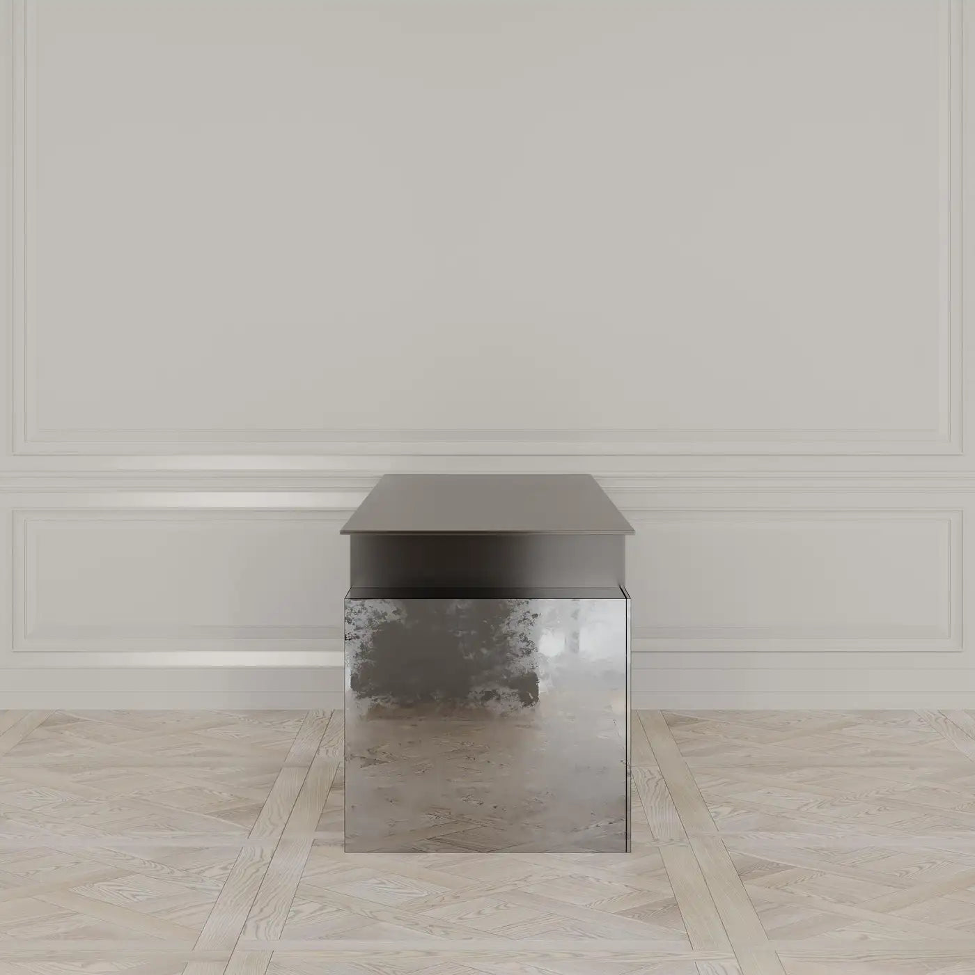Modern side table with metallic finish in a room with light-colored walls and floor.