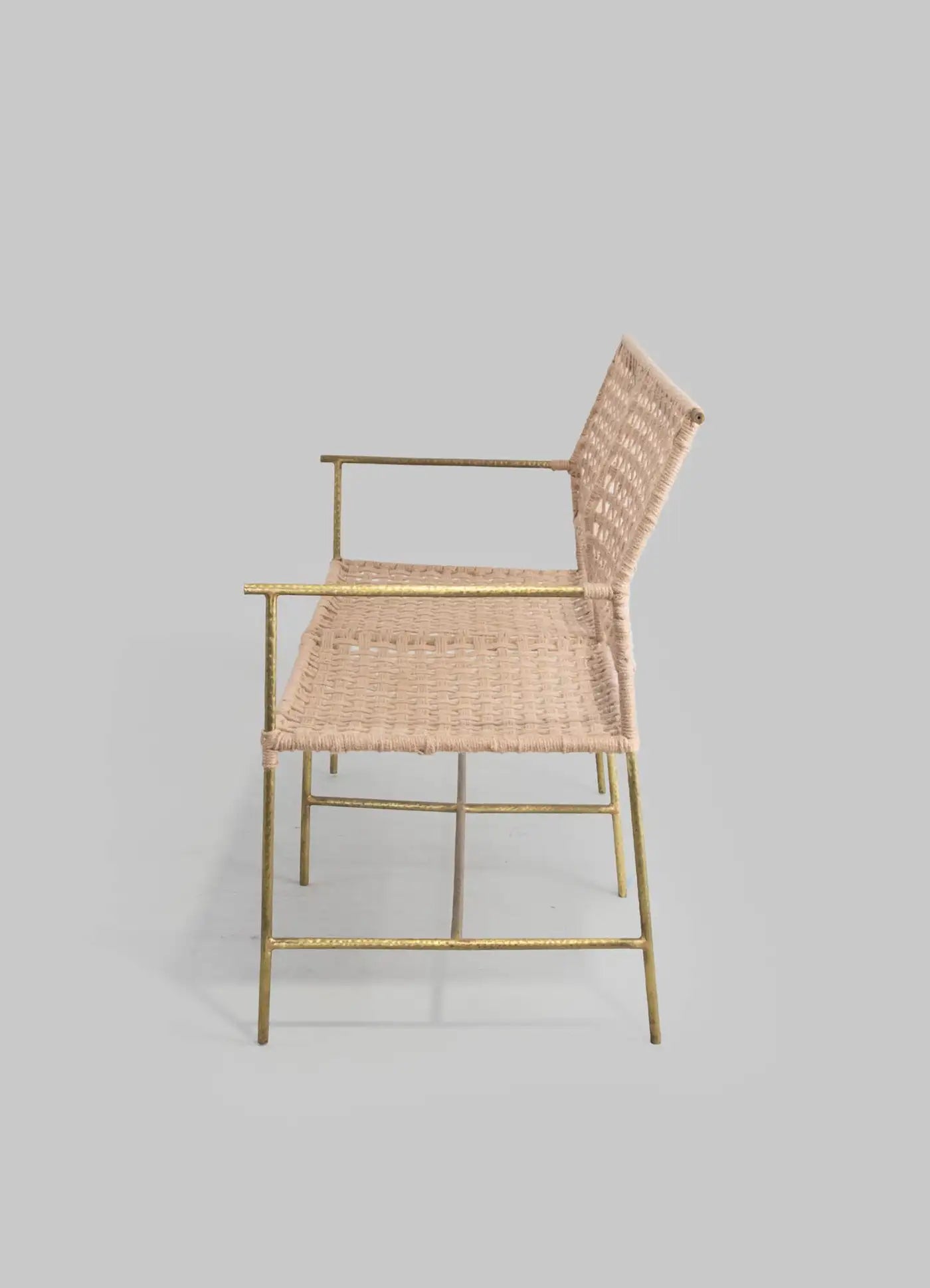 Wicker chair with gold metal frame on a light gray background