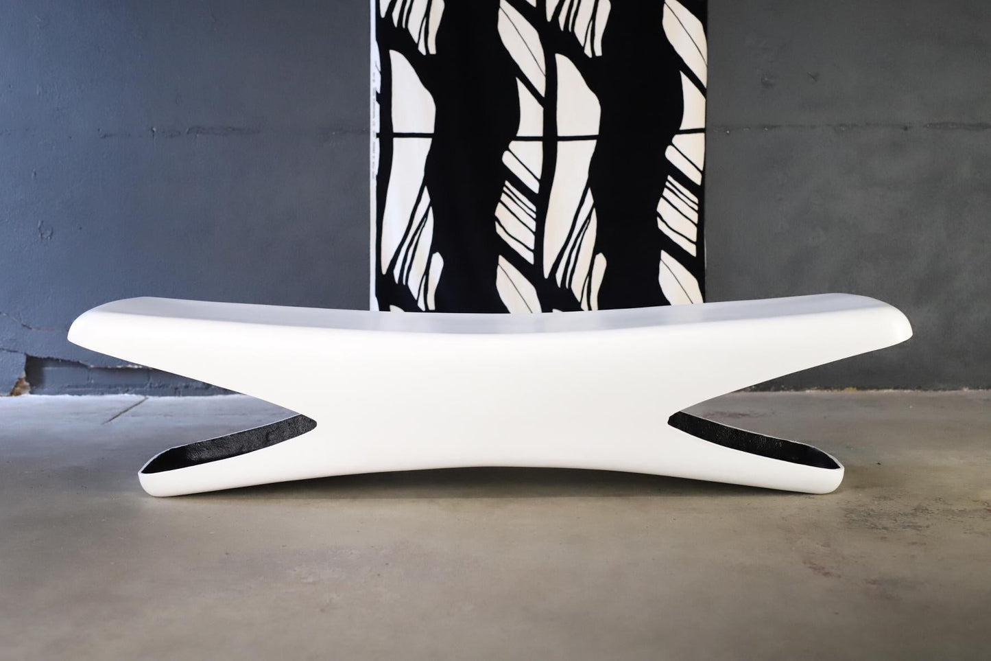 Modern white bench with a black and white abstract painting in the background