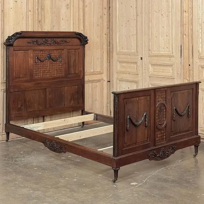 Vintage wooden bed with intricate carvings in a room with wooden panel walls.