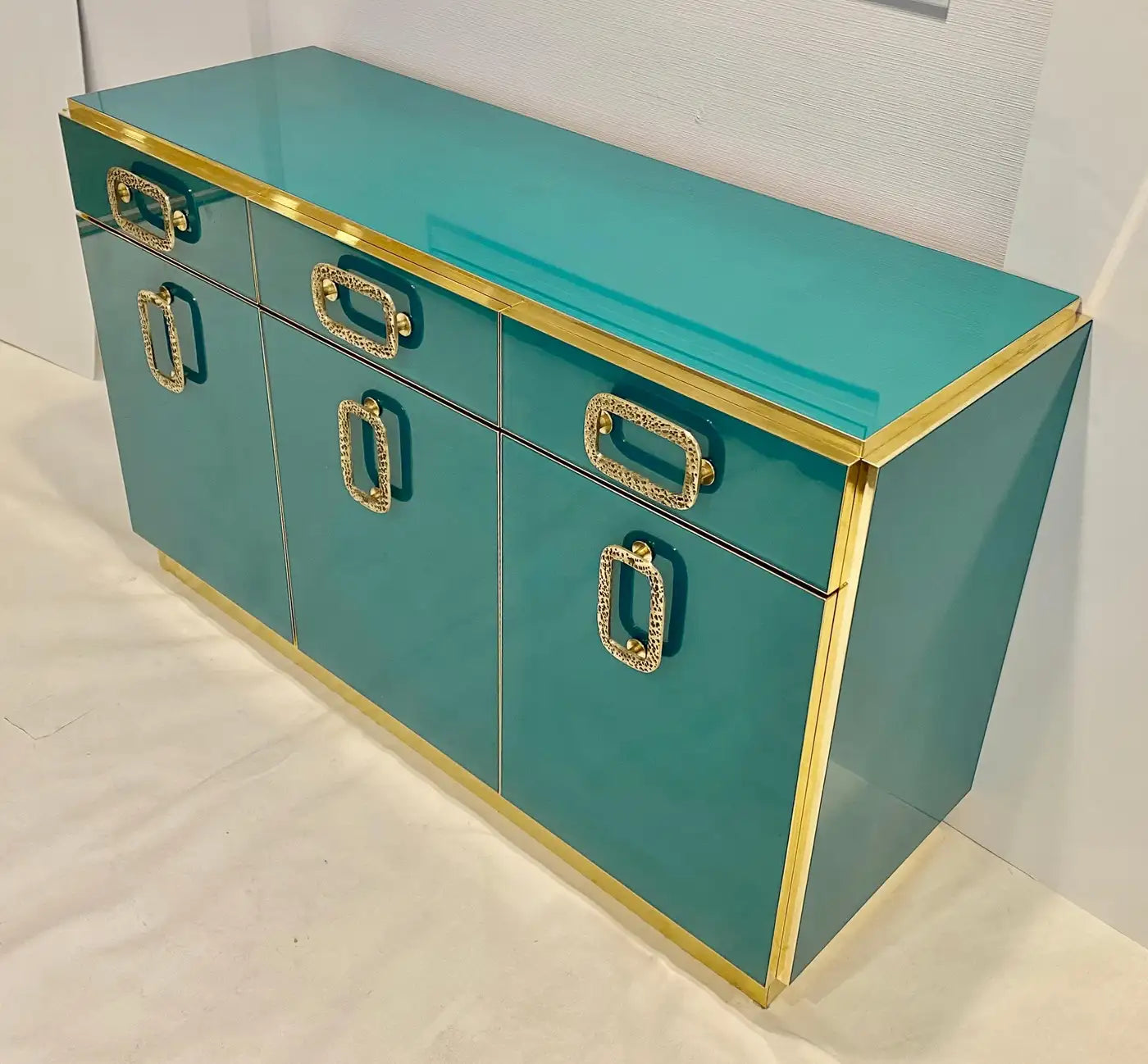 Teal console table with gold accents on a white background