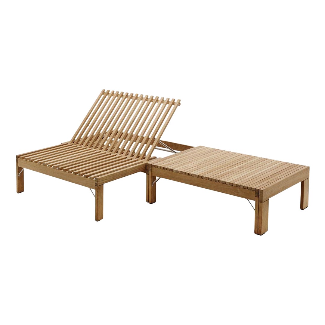 Wooden lounge chair with attached table on a white background