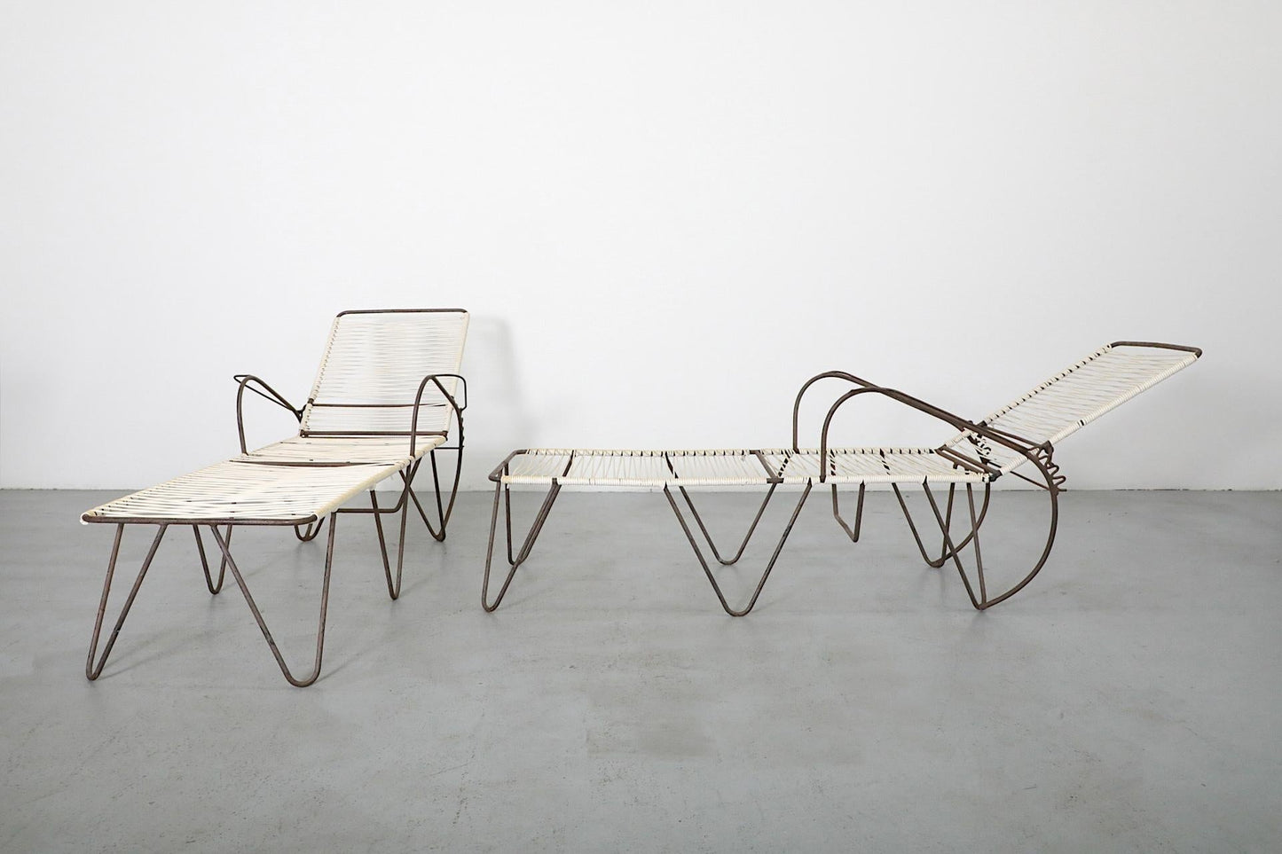 Modern lounge chair and ottoman on a gray floor with white background