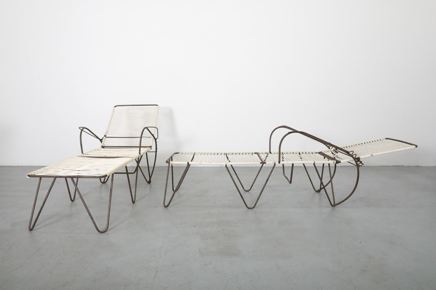 Modern lounge chair and table set on a gray floor with white background