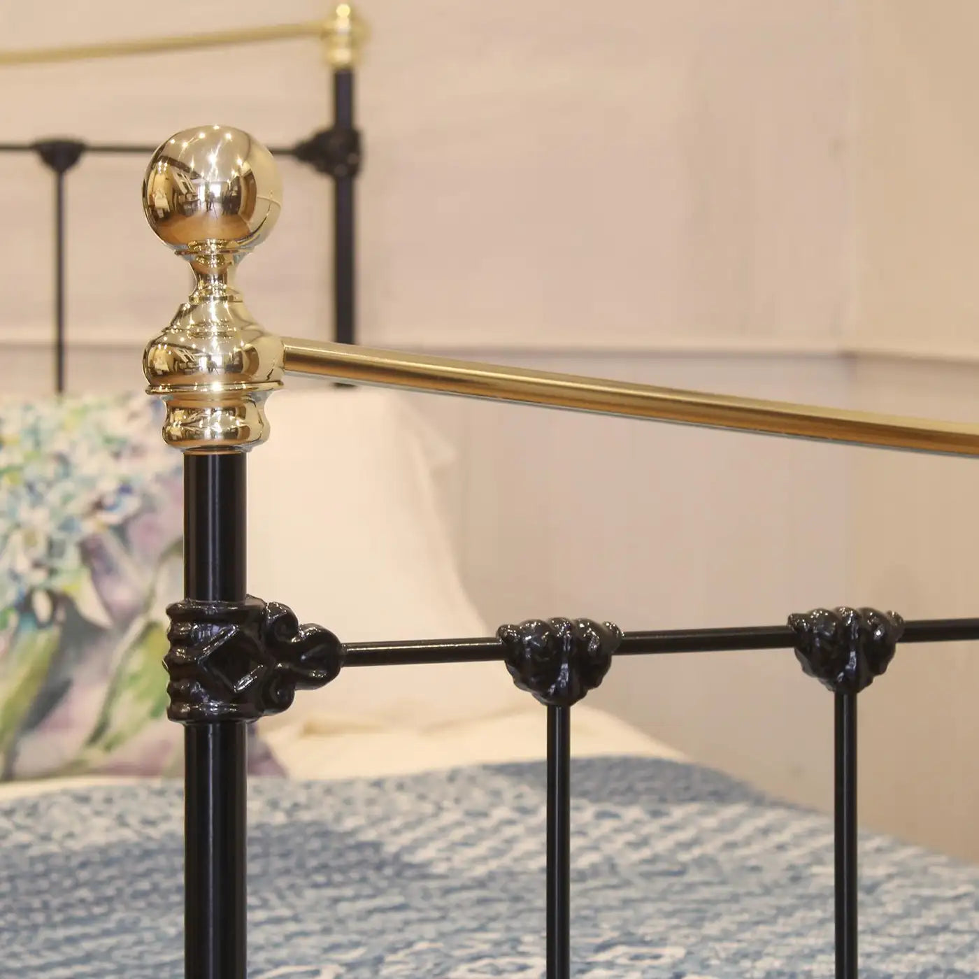 Close-up of a black metal bed frame with gold accents and decorative elements.