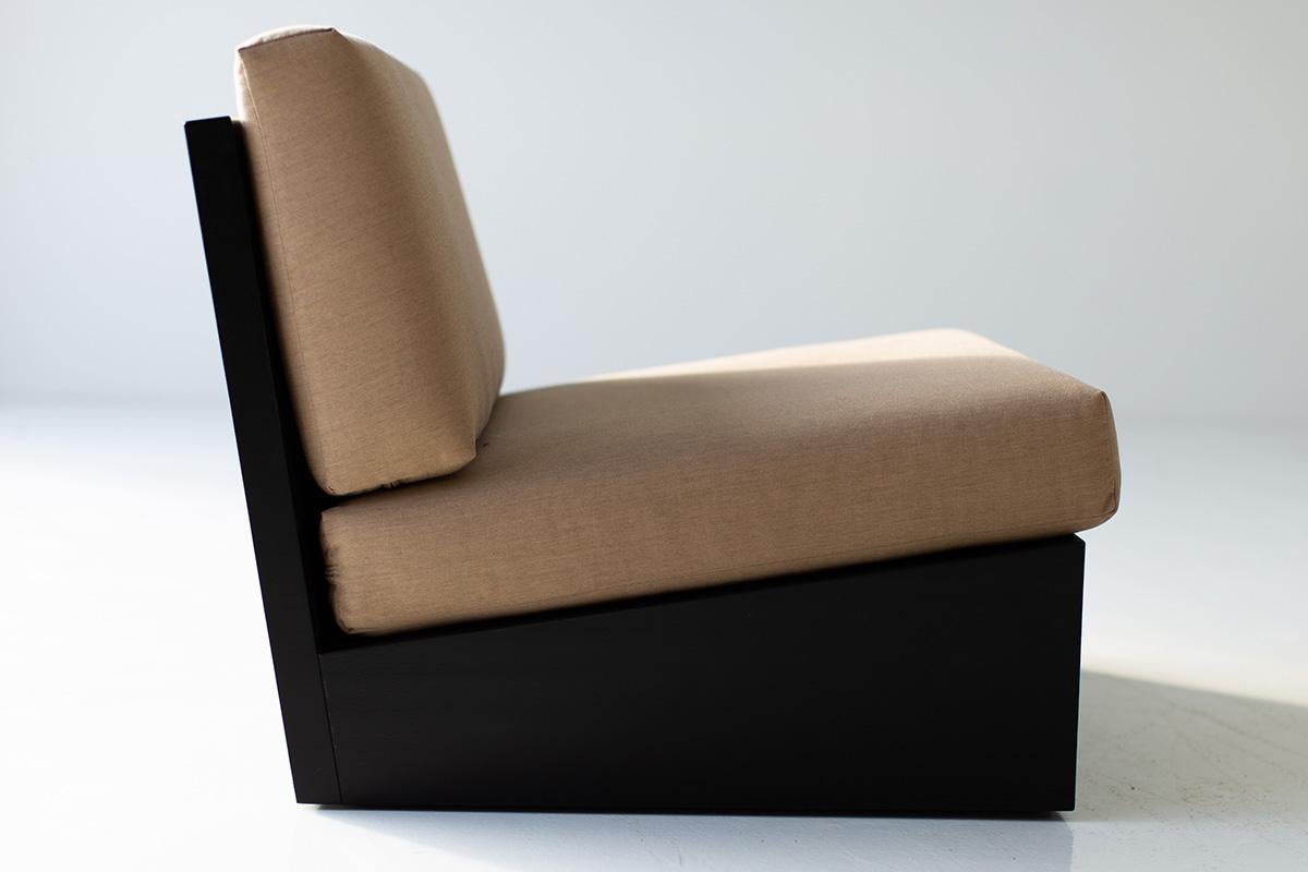 Modern chair with beige cushion and black frame on a white background