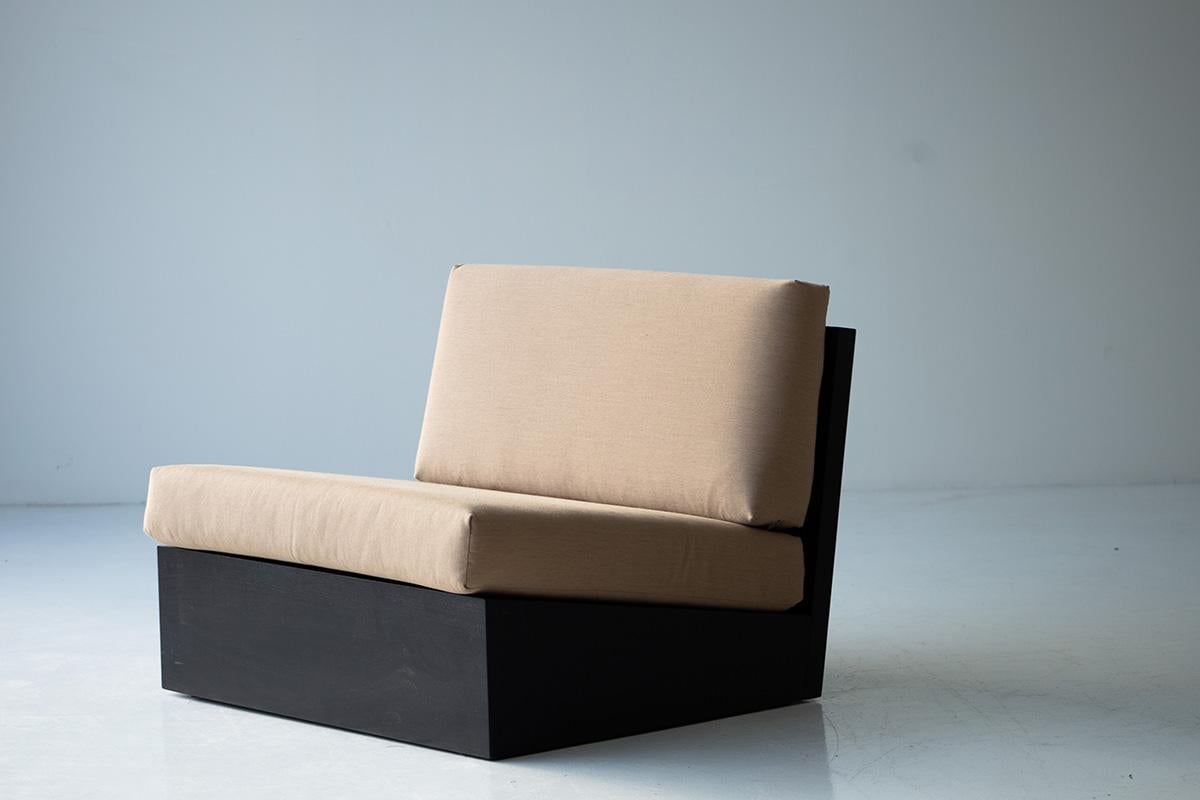 Modular sofa with beige cushions and black base on a plain background