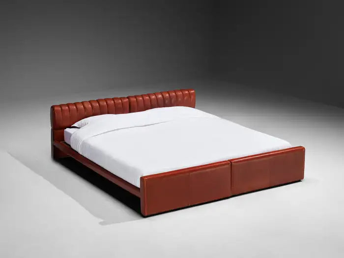 Red bed frame with white mattress on a gray background