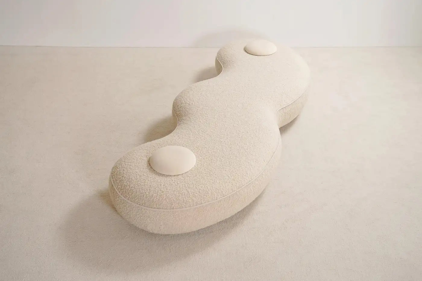 White ceramic vase with a smooth, organic shape on a light beige background