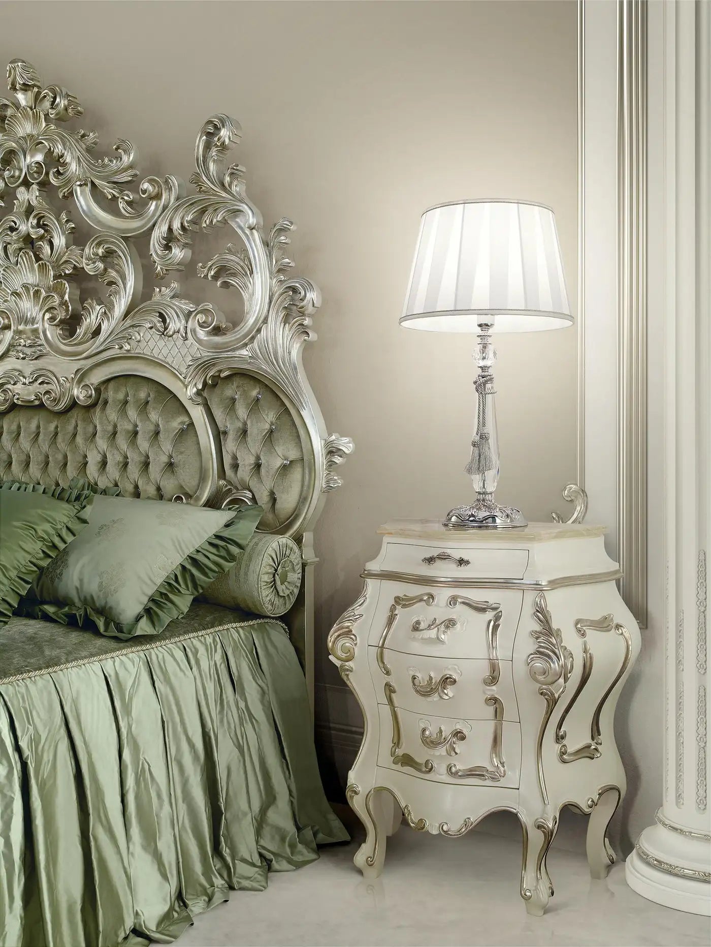 Decorative bedroom with ornate headboard and nightstand with lamp.