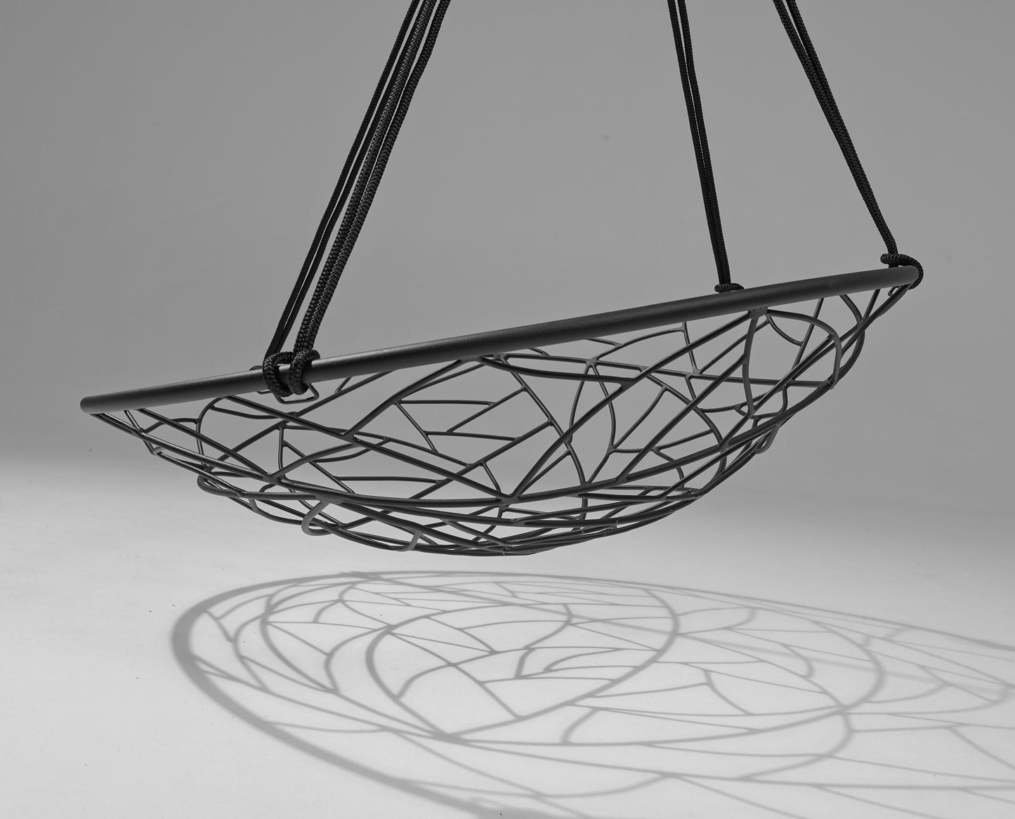 Black wire hammock chair on a gray background