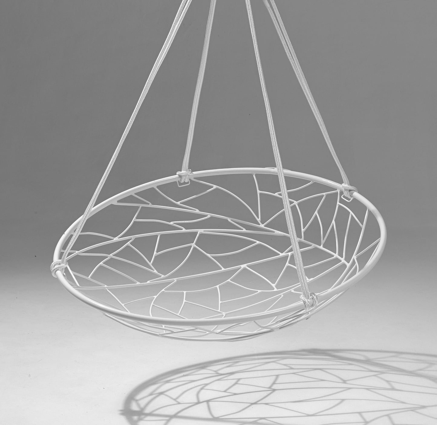 White hanging chair with geometric pattern on a gray background