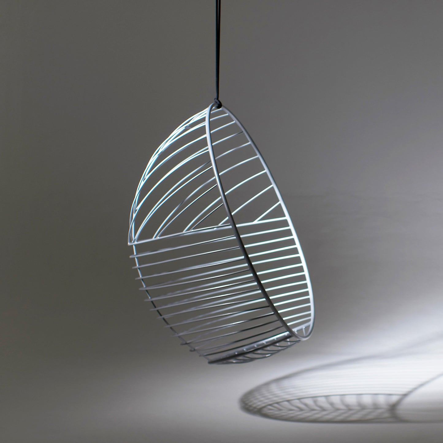 Modern pendant light with leaf-like design on a gray background