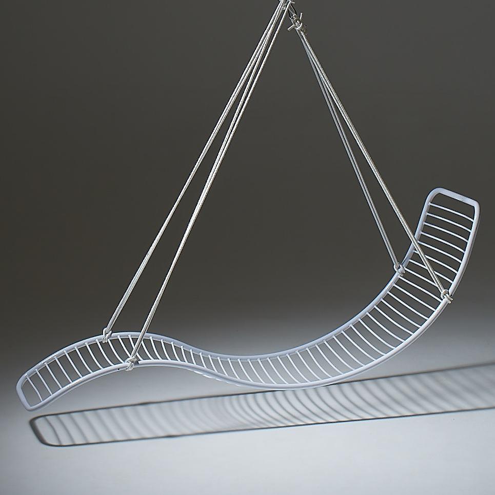 Modern white wire chair with curved design on a dark background