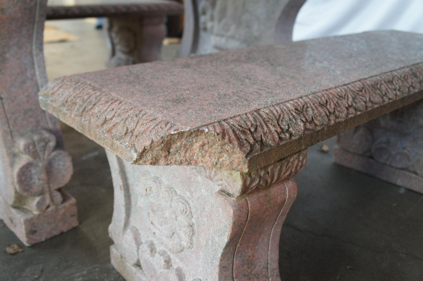 Stone bench with decorative carvings on a blurred background