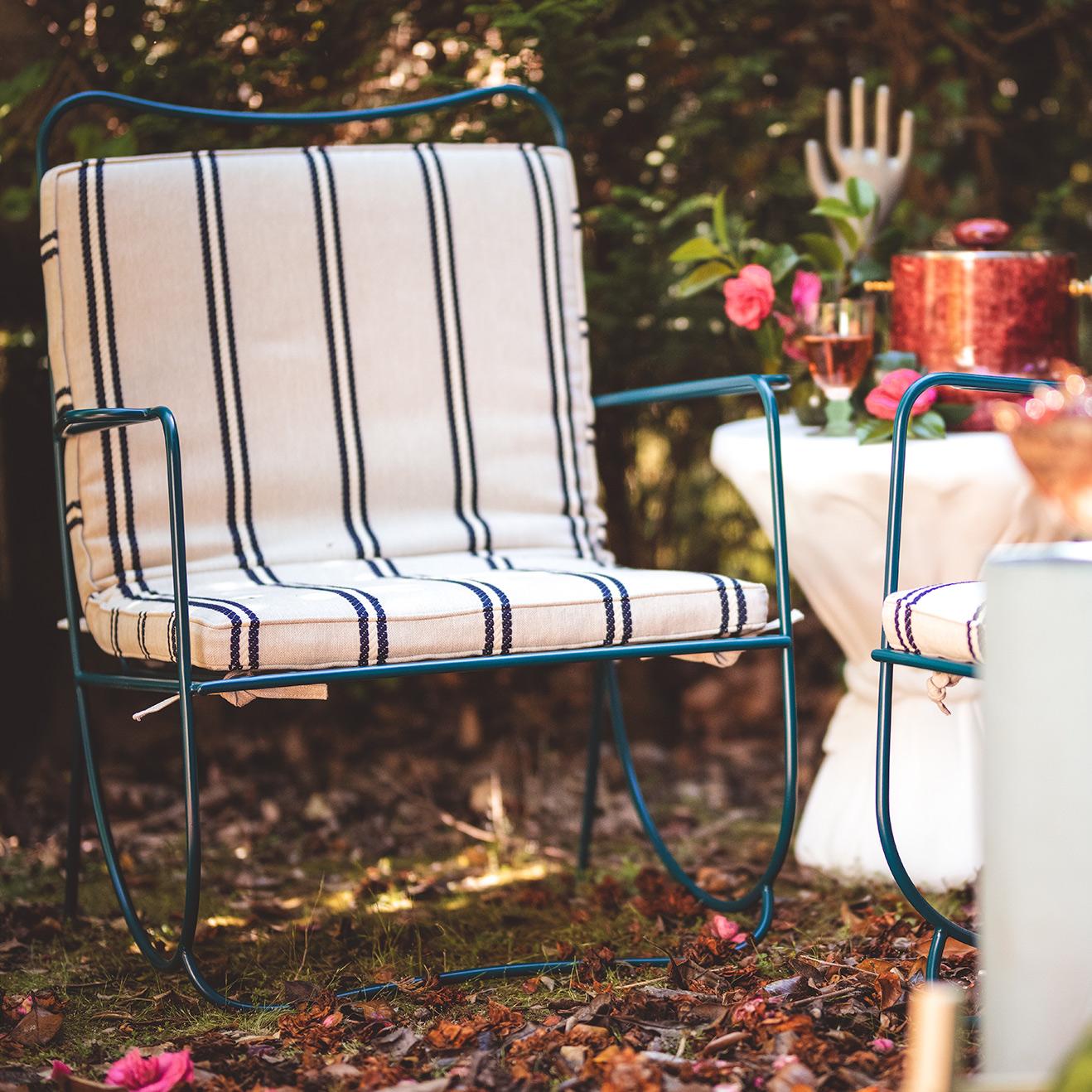 Outdoor chair with striped cushions in a garden setting