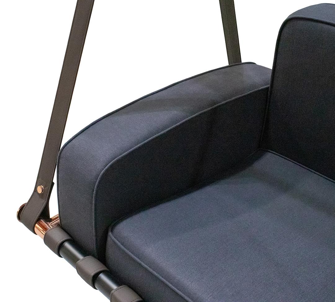 Gray cushioned swing with black metal frame on a white background