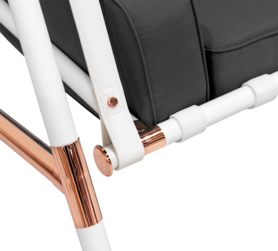 Close-up of a chair with white and rose gold frame on a gray background