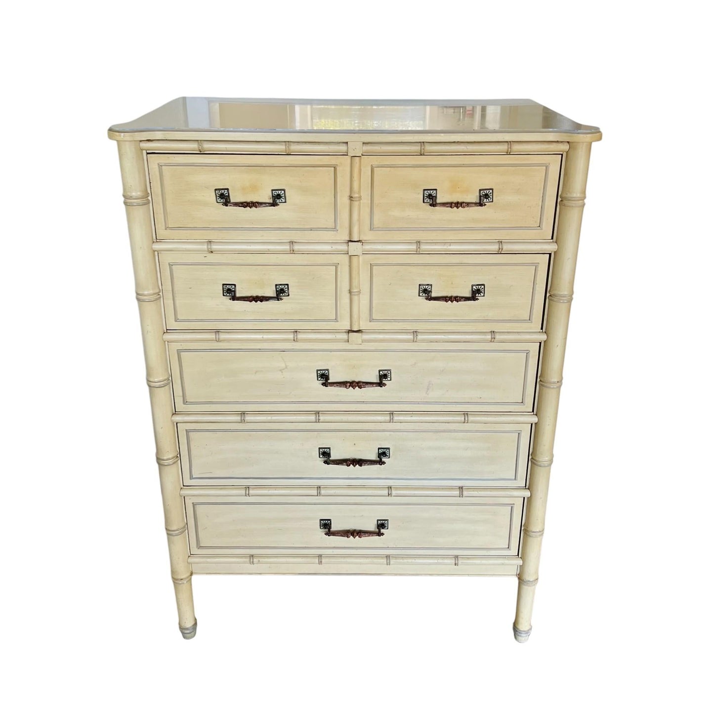 White dresser with bamboo-style design and glass top on a white background