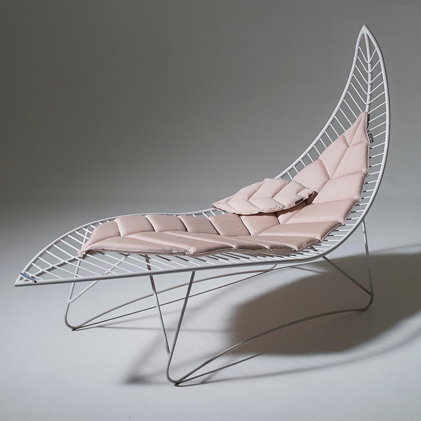 Modern lounge chair with pink cushion on a gray background