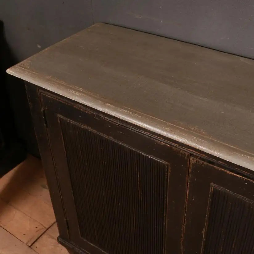Wooden cabinet with a gray top in a dimly lit room