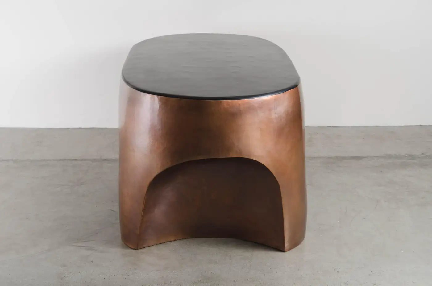 Wooden stool with a dark brown finish on a gray floor.
