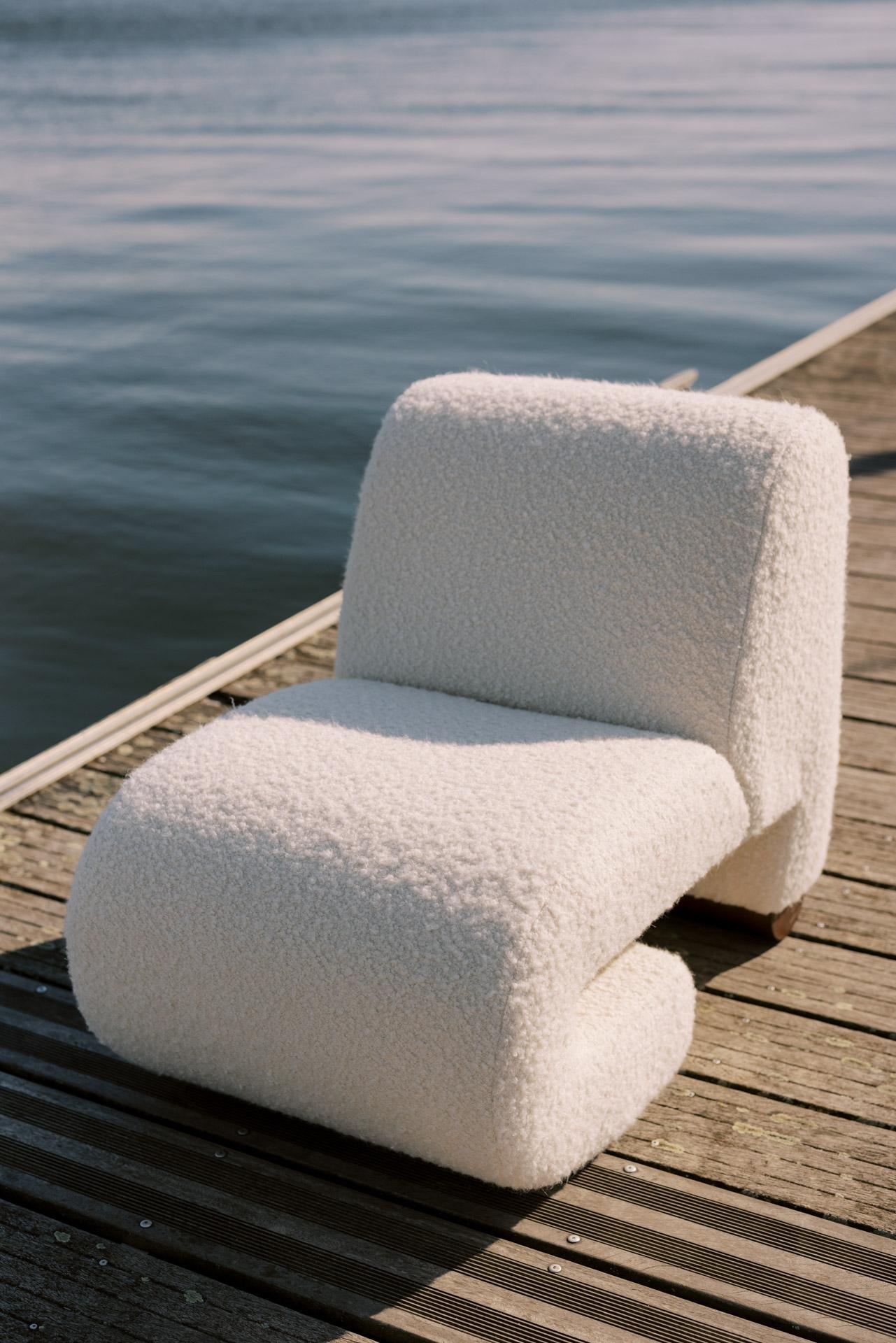 White textured chair on a wooden dock by a body of water