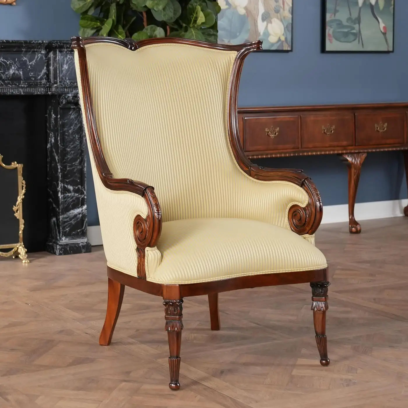 Vintage-style armchair with wooden frame and cream upholstery in a room with a fireplace and wooden desk.