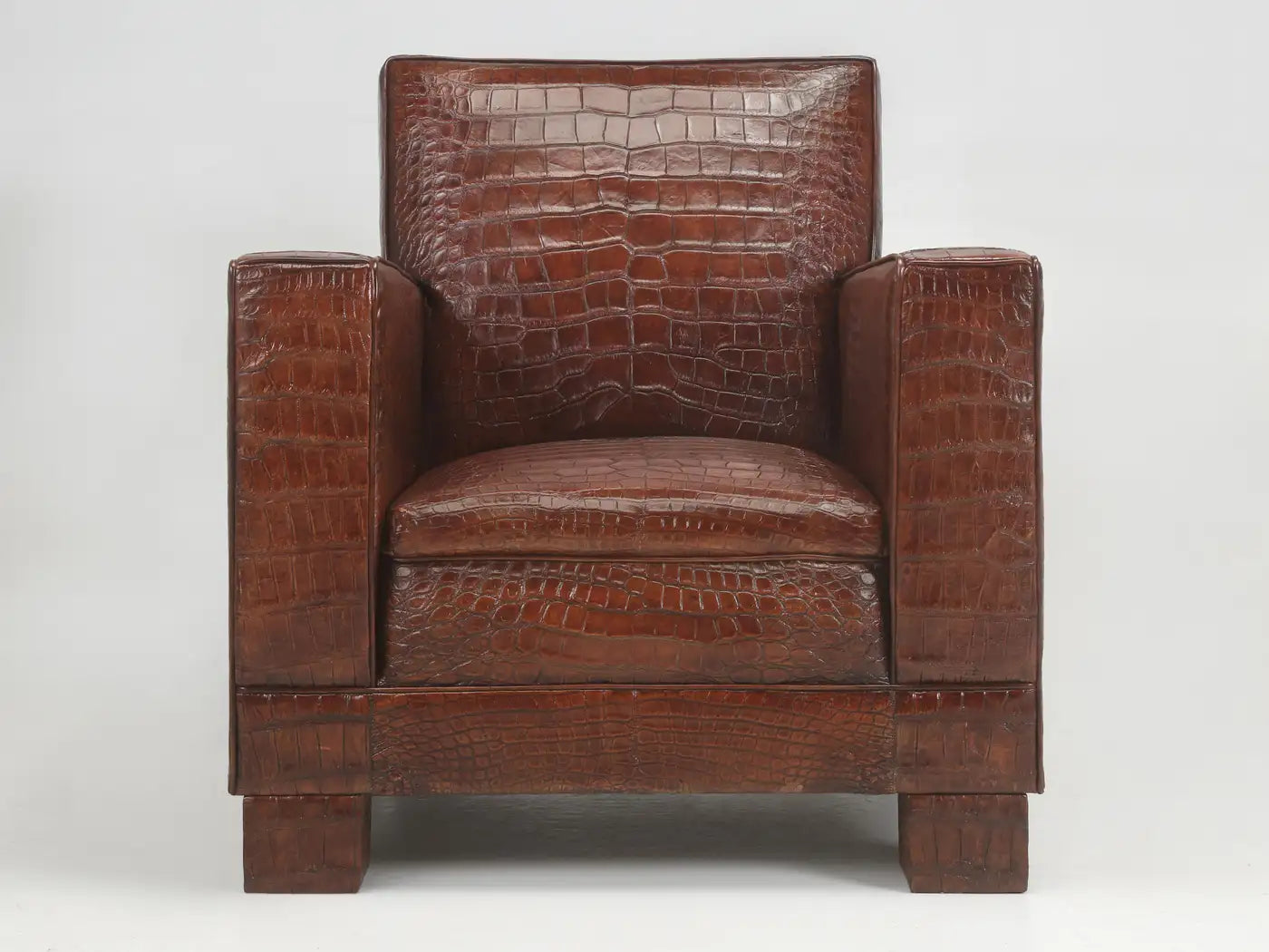 Brown leather armchair with crocodile texture on a white background