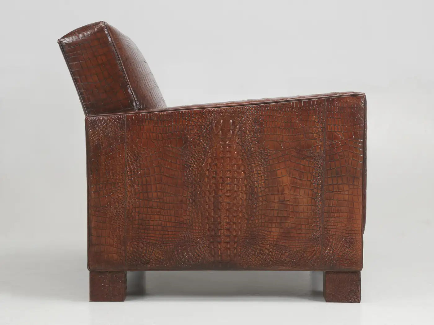 Brown leather armchair with crocodile texture on a white background