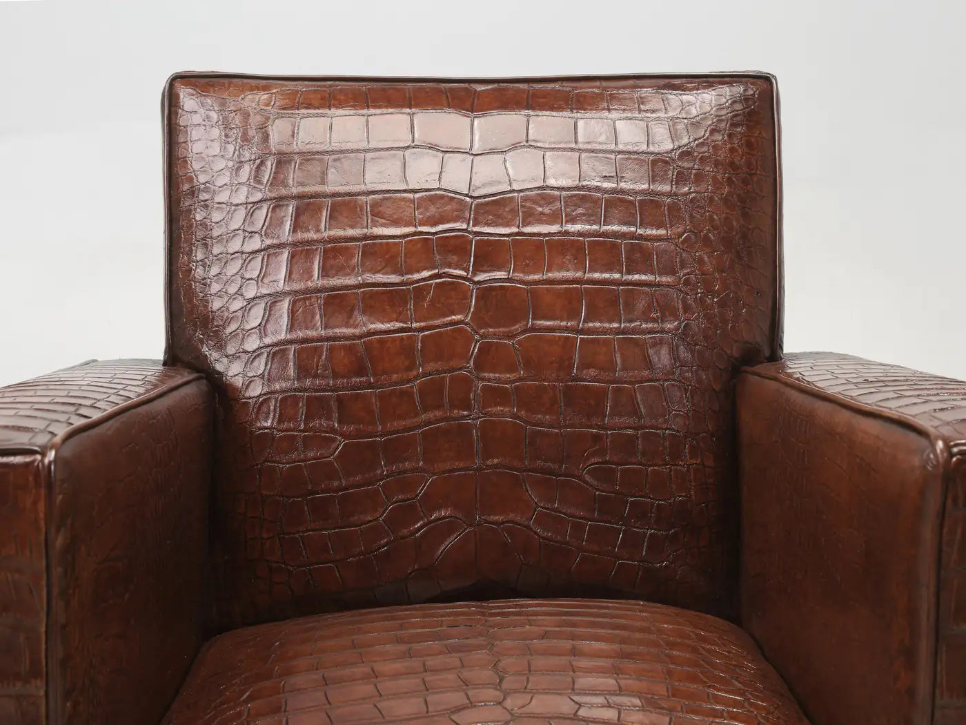 Brown crocodile-patterned leather armchair on a white background