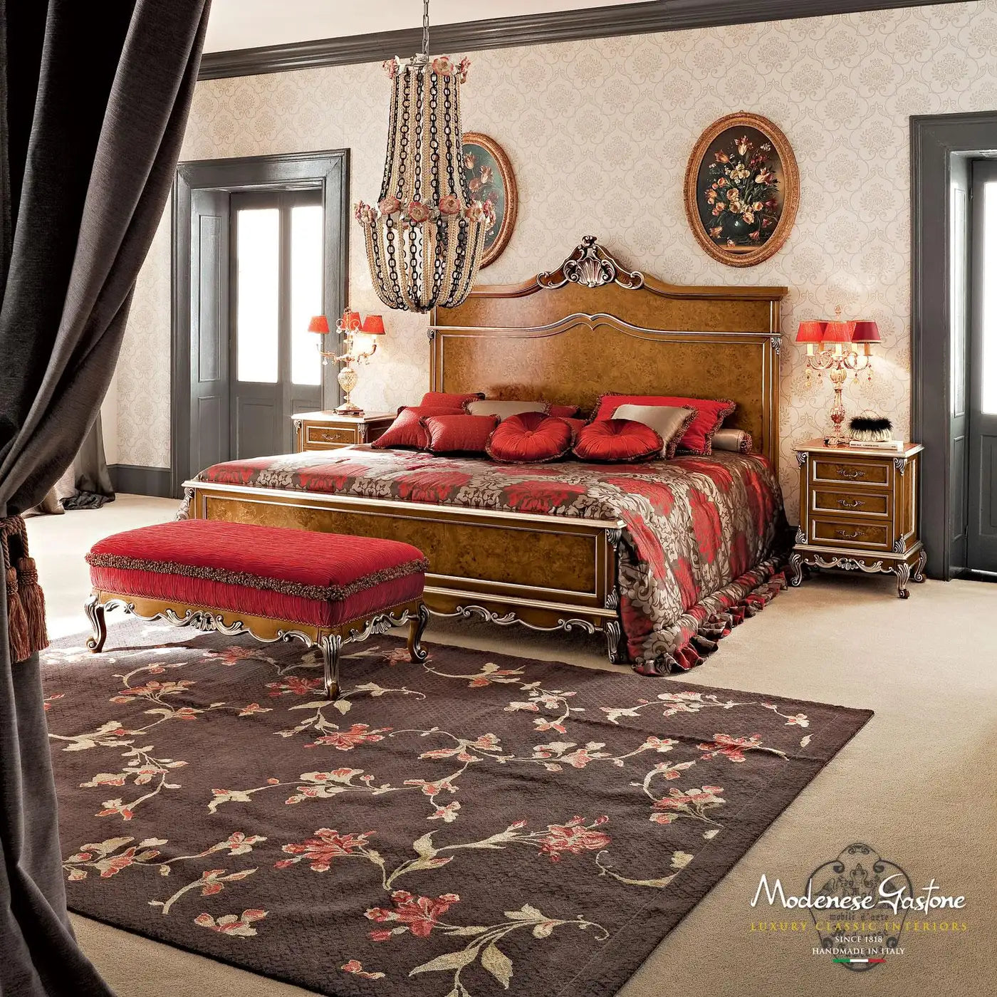 Luxurious bedroom with wooden bed, red bedding, and decorative rug.