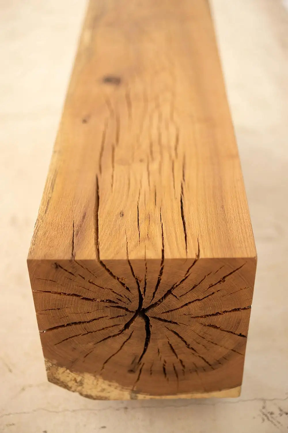 Close-up of a wooden beam with visible grain and texture on a light background