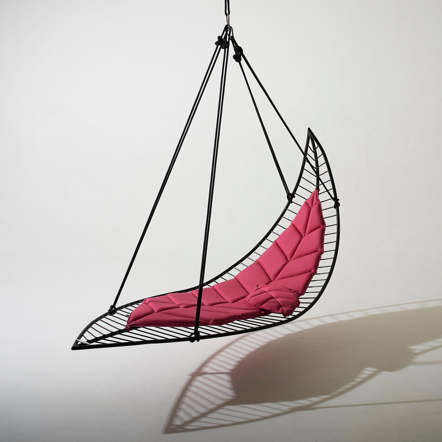 Hanging chair with pink cushion on a white background