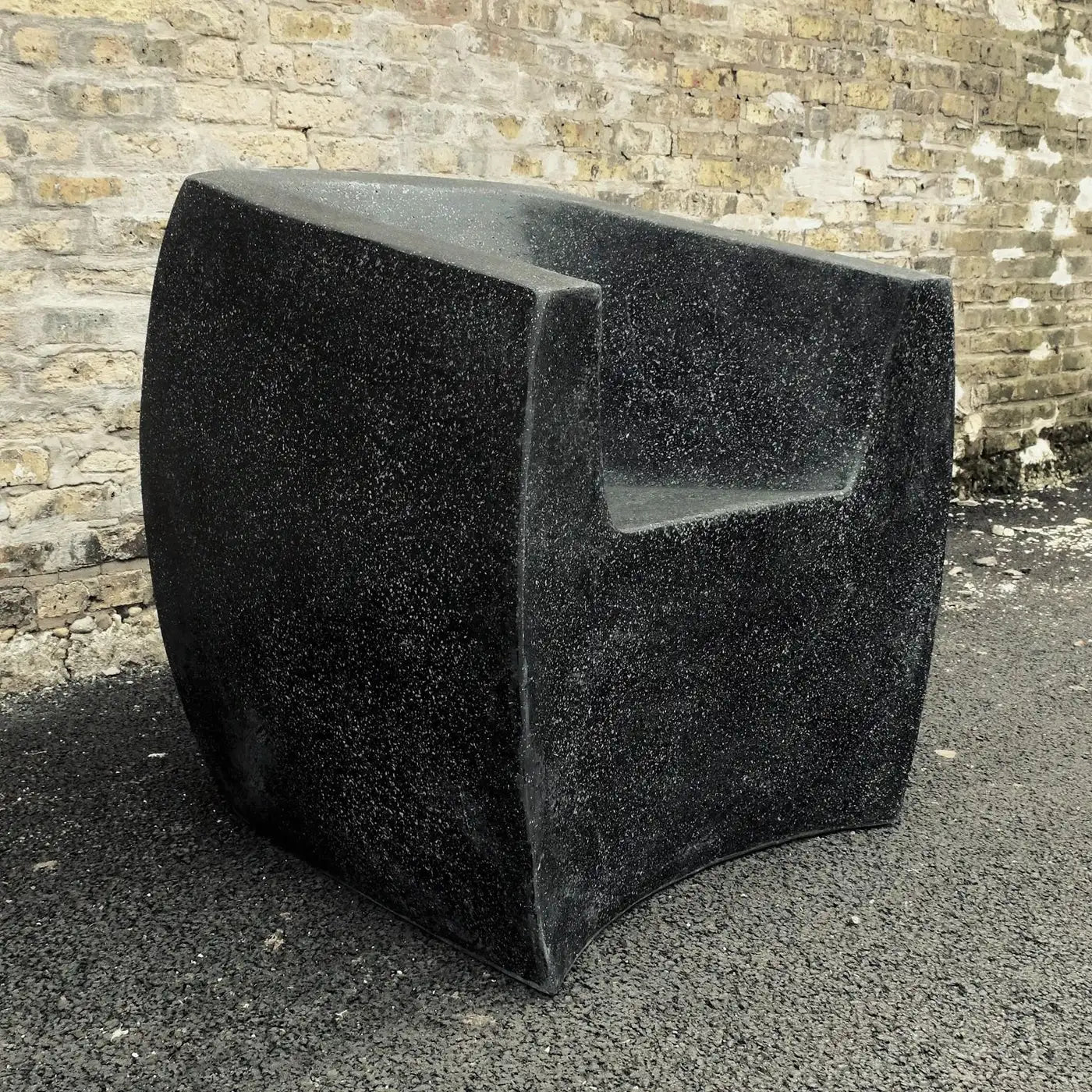 Black stone sculpture against a brick wall