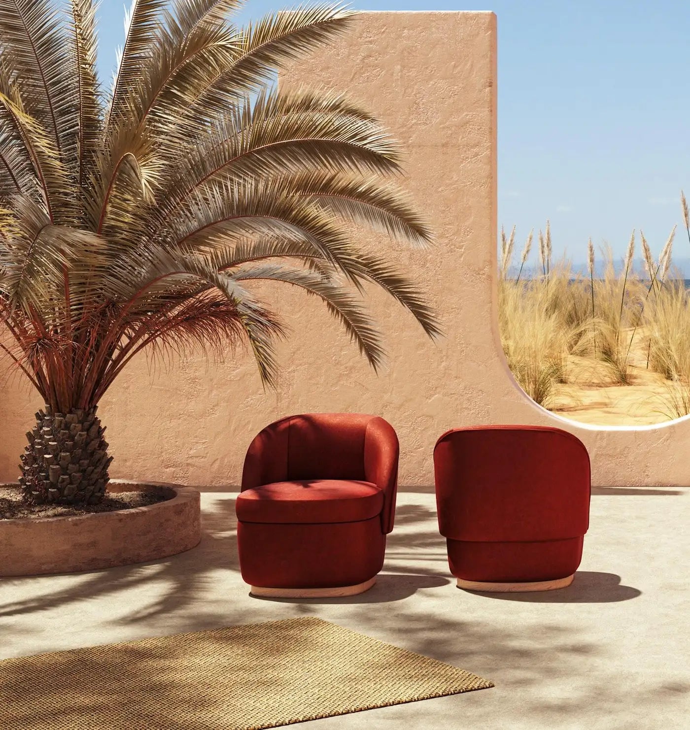 Two red chairs in a desert-like setting with a palm tree and beige wall.