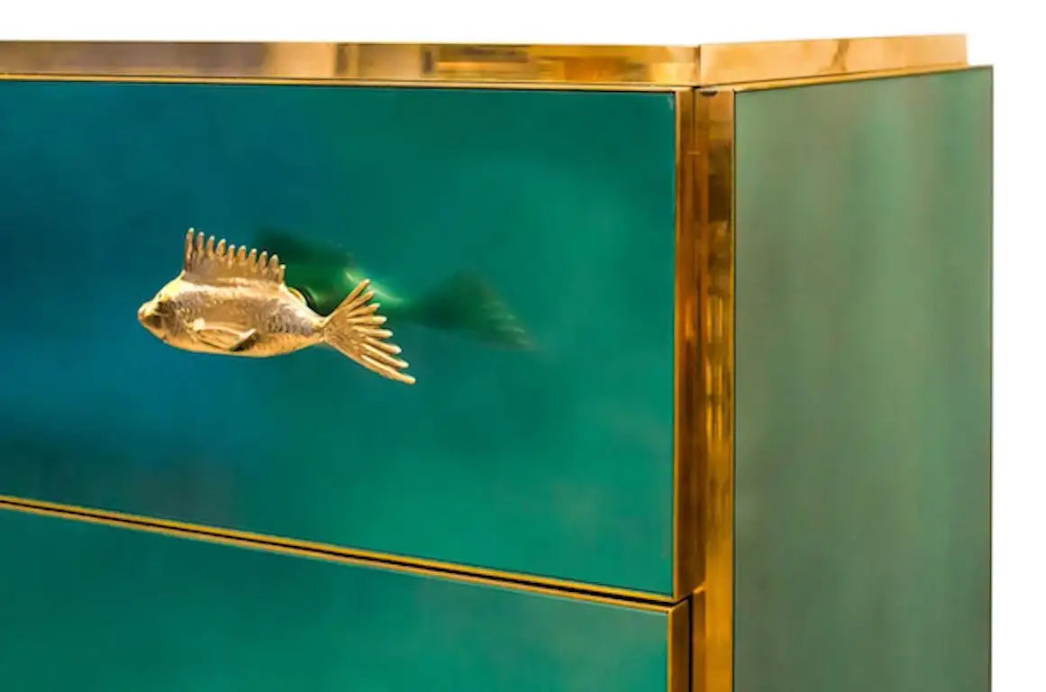 Green cabinet with gold fish-shaped handle on a white background