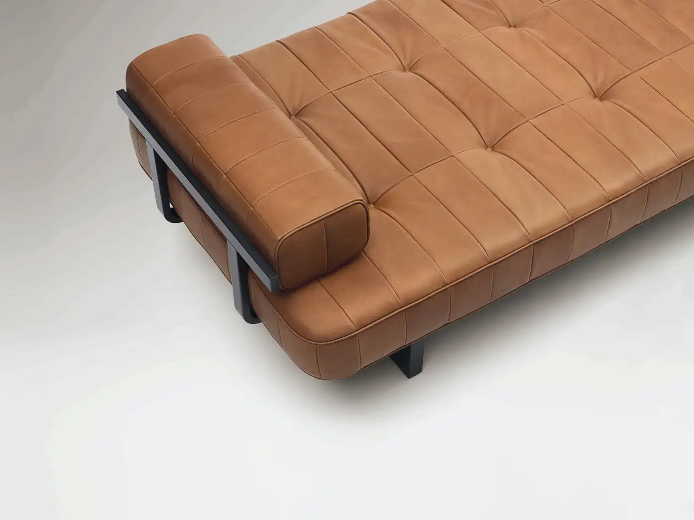 Brown leather sofa with black metal frame on a white background