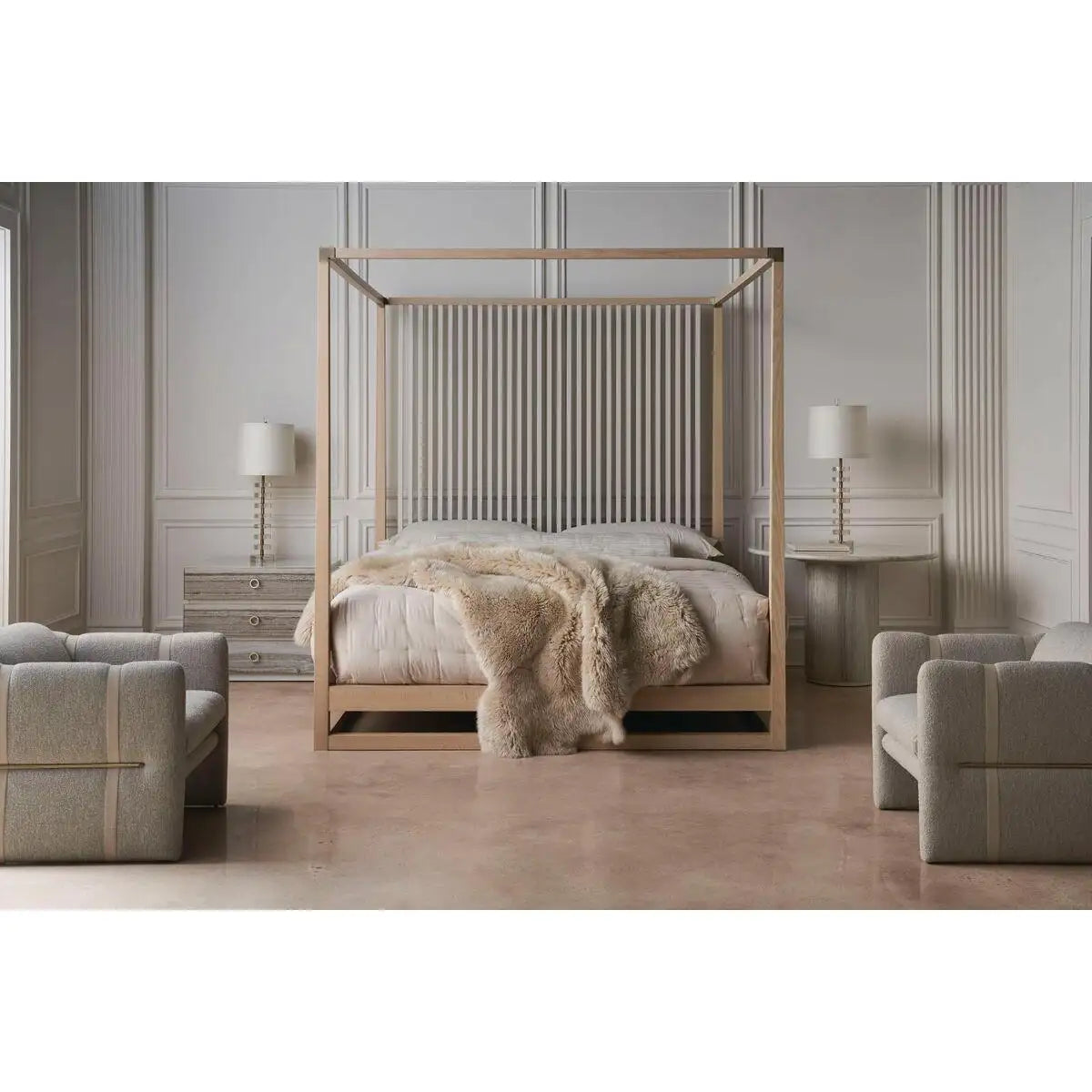 Wooden canopy bed with bedding and a fur throw in a bedroom setting.