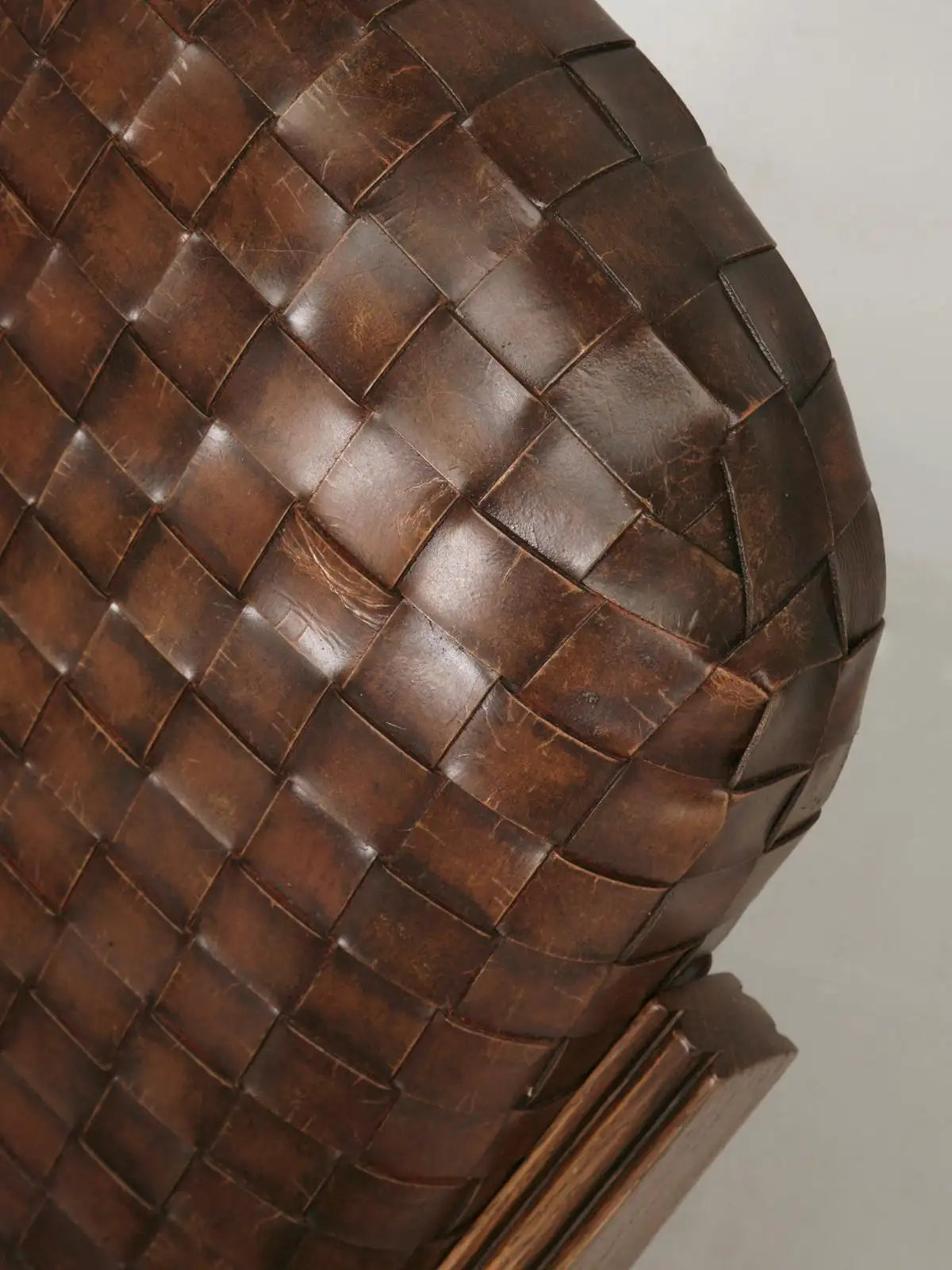 Close-up of a woven brown leather bag on a light background