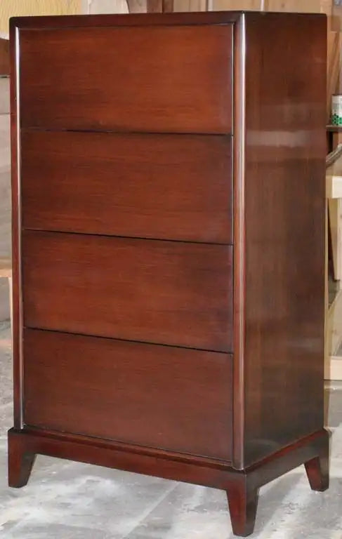 Wooden dresser with three drawers on a gray floor.
