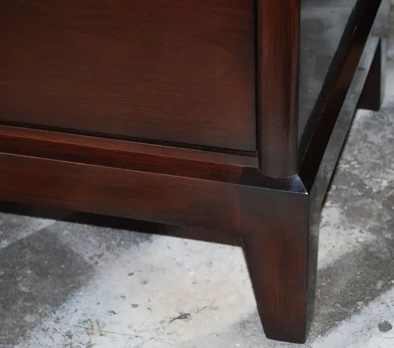 Close-up of a wooden furniture leg on a textured floor