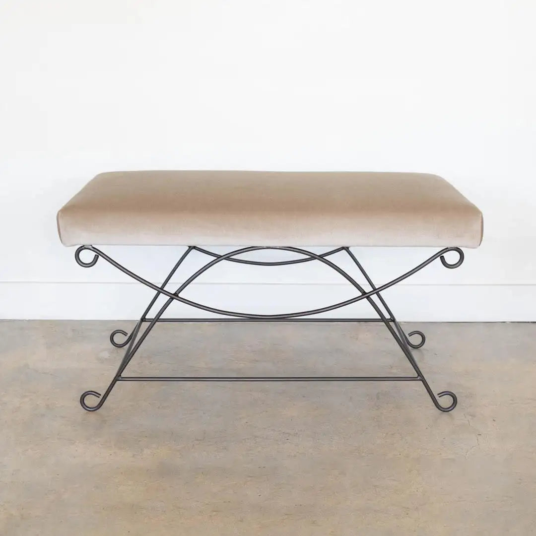 Bench with beige cushion and metal frame on a plain background