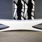 Modern white bench with a black and white abstract painting in the background