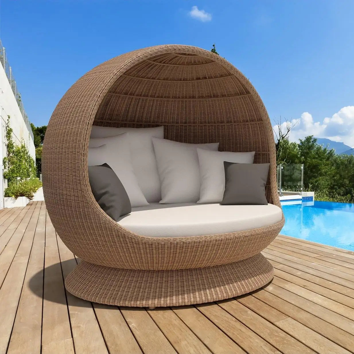 Wicker outdoor pod with cushions by a pool on a wooden deck