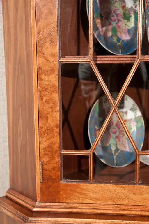 Wooden cabinet with glass panels displaying decorative plates