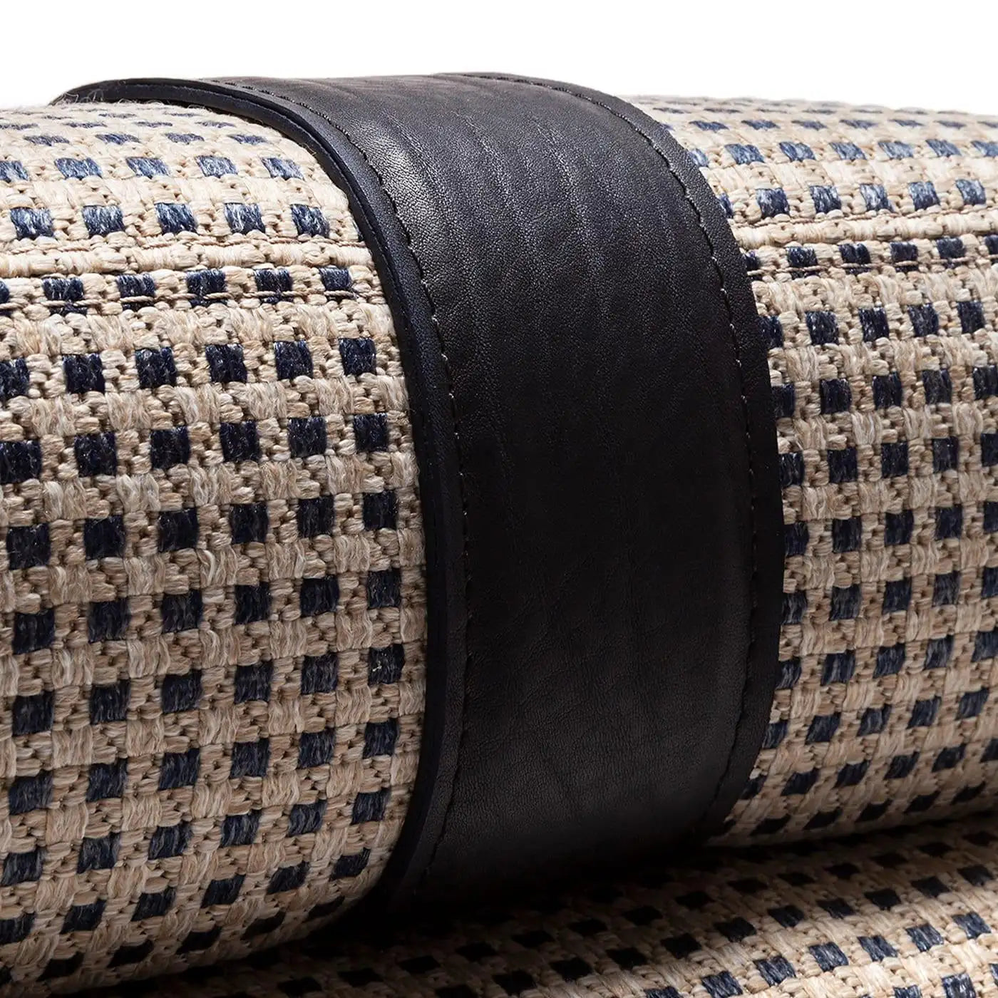 Close-up of a rolled-up rug with a checkered pattern and black border.