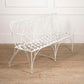 White metal bench with decorative backrest on a wooden floor