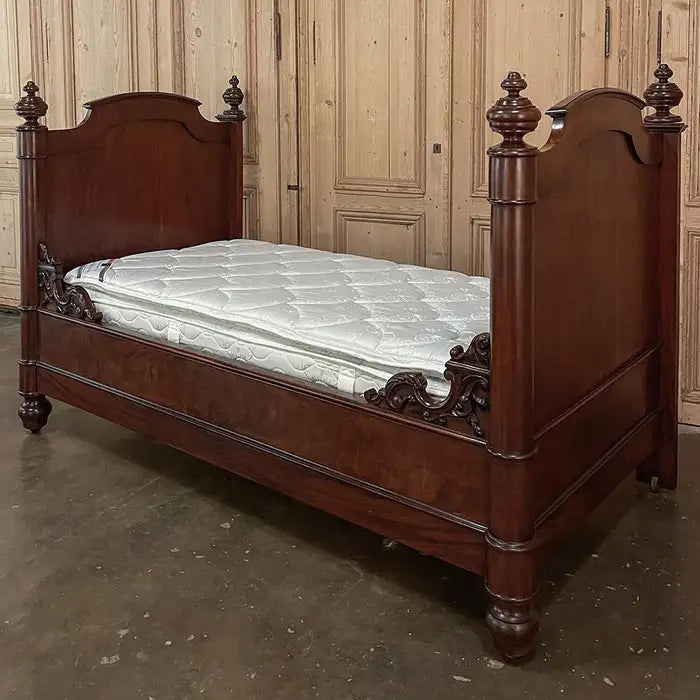 Wooden bed with a mattress in a room with wooden paneling.