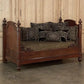 Vintage-style wooden sofa with decorative cushions against a wooden paneled wall.
